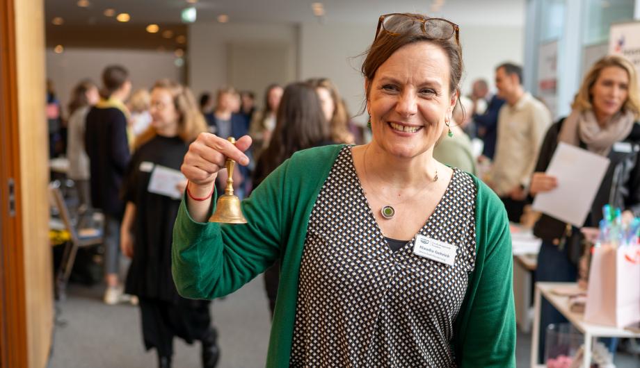 Frau mit Glöckchen im Foyer der IHK Potsdam bei Frauen auf dem Weg 2024
