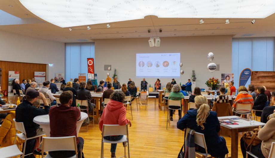 Evelyn Kubein, Marvin Abert, Bernd Rubelt, Thorsten Jahnke, Tina Knop und Doreen Löwe auf der Bühne der IHK mit Publikum