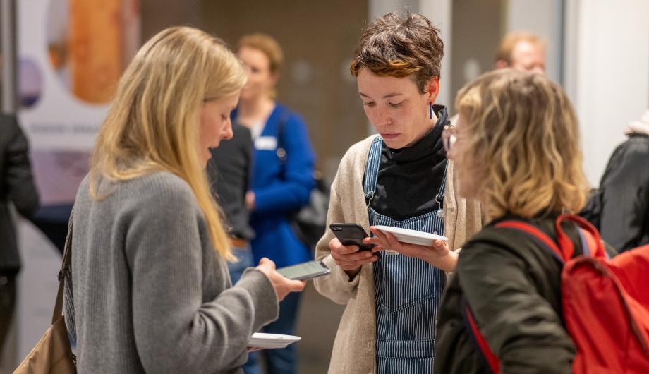 Frauen, die ihre Telefonnummern austauschen im Foyer der IHK bei Frauen auf dem Weg 2024
