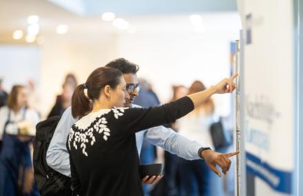 2 Personen schauen auf eine Infotafel
