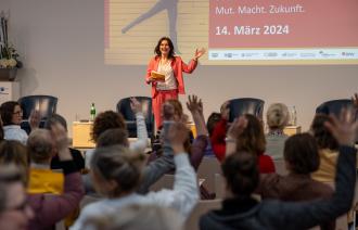 Moderatorin Tina Knop auf der Bühne vor Publikum bei Frauen auf dem Weg 2024 in der IHK Potsdam