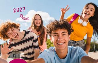 4 junge Menschen in bunter Kleidung lachen in die Kamera