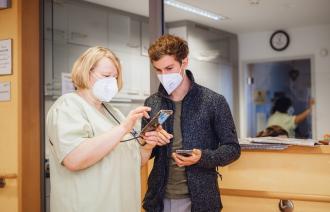 Zwei Personen mit Smartphone in der Hand