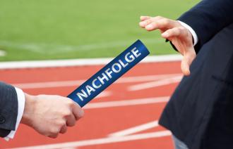 Übergabe eines Staffelstabs, auf dem "Nachfolge steht", von einer Hand in die andere