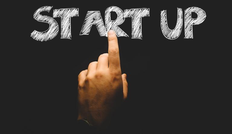 Hand mit ausgestrecktem Zeigefinger, der auf das Wort "Start up" zeigt