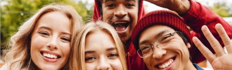 4 junge Menschen lächeln in die Kamera