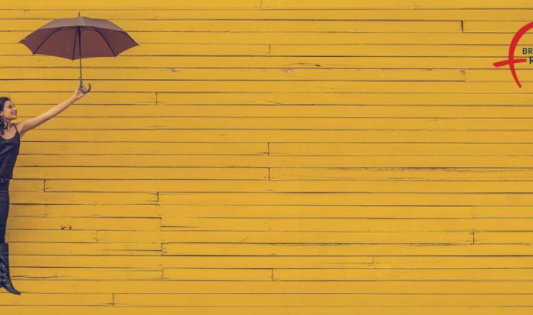 Frau mit Regenschirm auf gelben Hintergrund